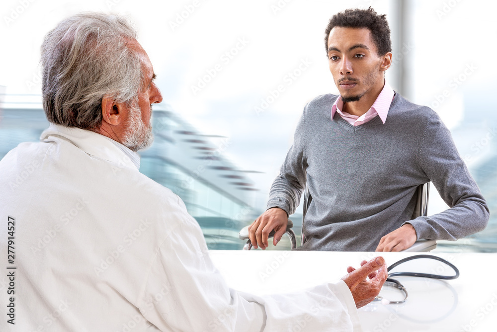 Fototapeta premium YongMale patient having consultation with senior male doctor in medical office.