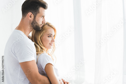 beautiful couple hugging at home in morning with sunlight