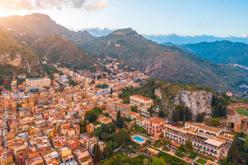 Taormina is a city on the island of Sicily, Italy. Aerial view from above in the evening at sunset light.
