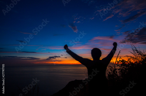 Silhouette Men love adventure travel photography. Black Rock View Point, Phuket Thailand Twilight evening in the tropics