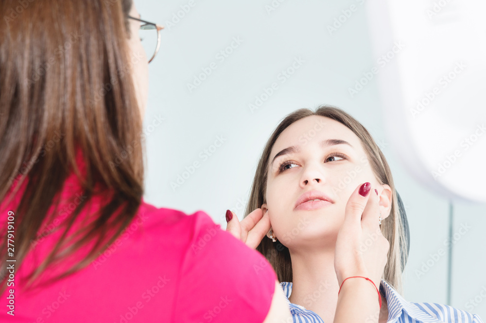 Dentist woman doctor talking to a young patient sitting on the dentist chair in a medical office. The first conversation with the client and external visual inspection Dentist woman doctor talking to a young patient sitting on the dentist chair in a medical office. The first conversation with the client and external visual inspection