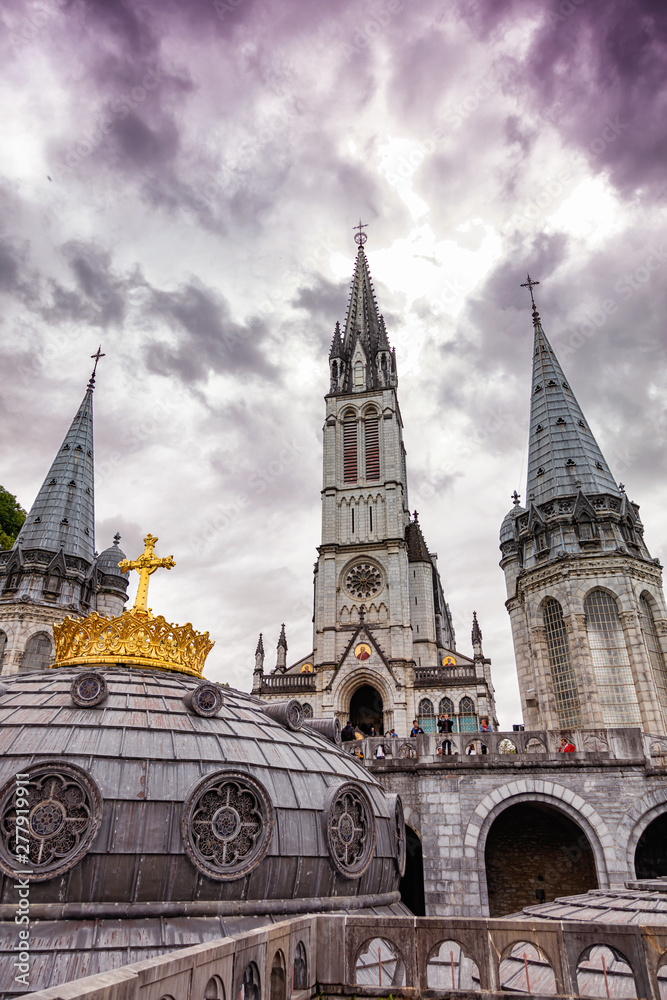 Christian gold cross on the roof of the Basilica of Our Lady of the Rosary in Lourdes, France Christian gold cross on the roof of the Basilica of Our Lady of the Rosary in Lourdes, France