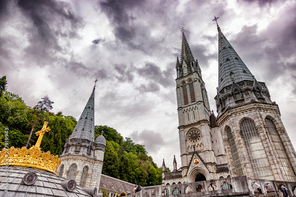 Christian gold cross on the roof of the Basilica of Our Lady of the Rosary in Lourdes, France Christian gold cross on the roof of the Basilica of Our Lady of the Rosary in Lourdes, France