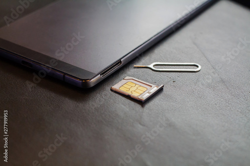 nano sim card in the store and SIM card adapter to change the size to a micro sim card and the usual SIM card size on a black cushion background.