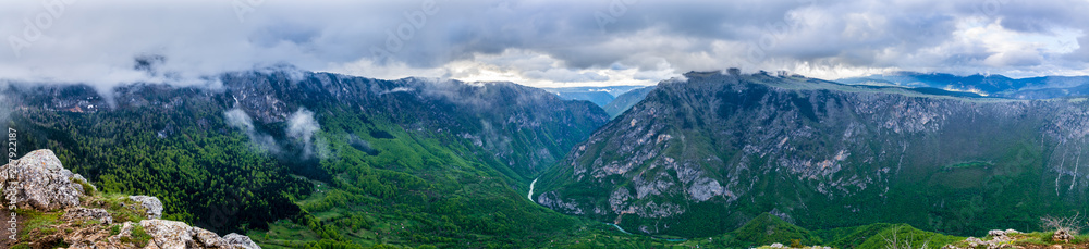 Montenegro, XXL panorama of green tara river canyon nature landscape from peak of mount curevac with dramatic cloudy sky in durmitor national park