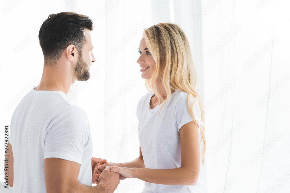 beautiful happy couple in pajamas holding hands at home beautiful happy couple in pajamas holding hands at home