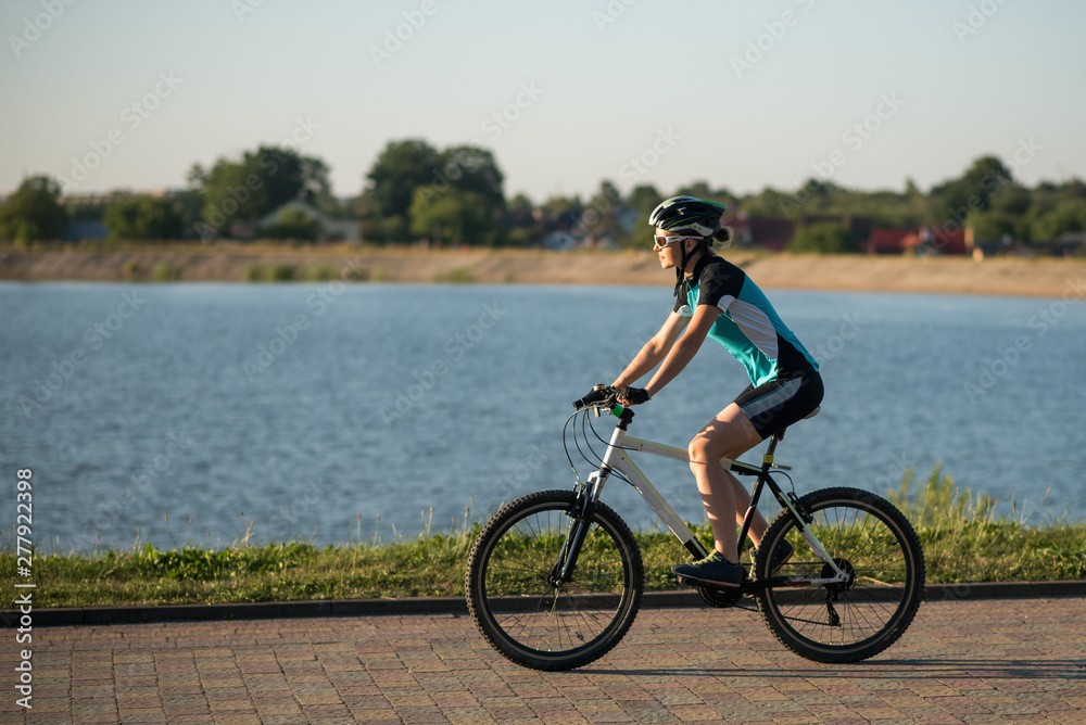 Woman on bike at the lake water background in the park