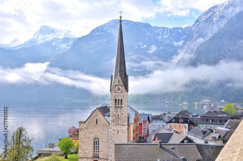 Amazing Hallstatt village with beautiful lake and alps mountains on background. Austria landmark with historic cathedral and wooden houses on the lake. Unesco heritage. Romantic view 