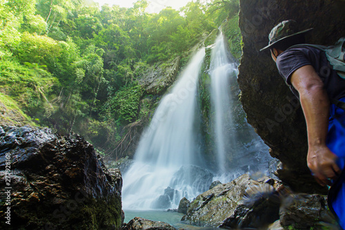 Men love to travel and hiking Adventure photographed young Thai people in Asia. Take yourself while walking on the Tam nang waterfall  in the forest tropical zone national park  Phang Nga Thailand.
