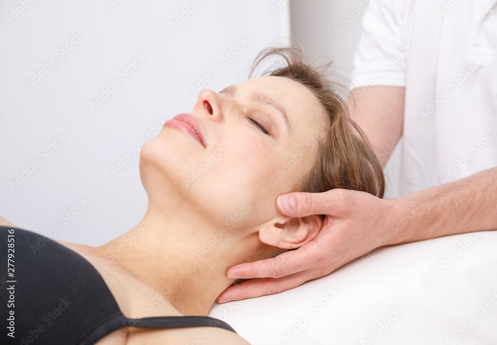 Woman receiving osteopathic treatment of her neck Woman receiving osteopathic treatment of her neck