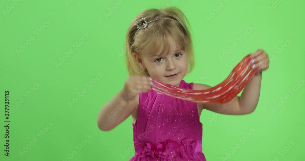 Child having fun making red slime. Kid playing with hand made toy slime Child having fun making red slime. Kid playing with hand made toy slime