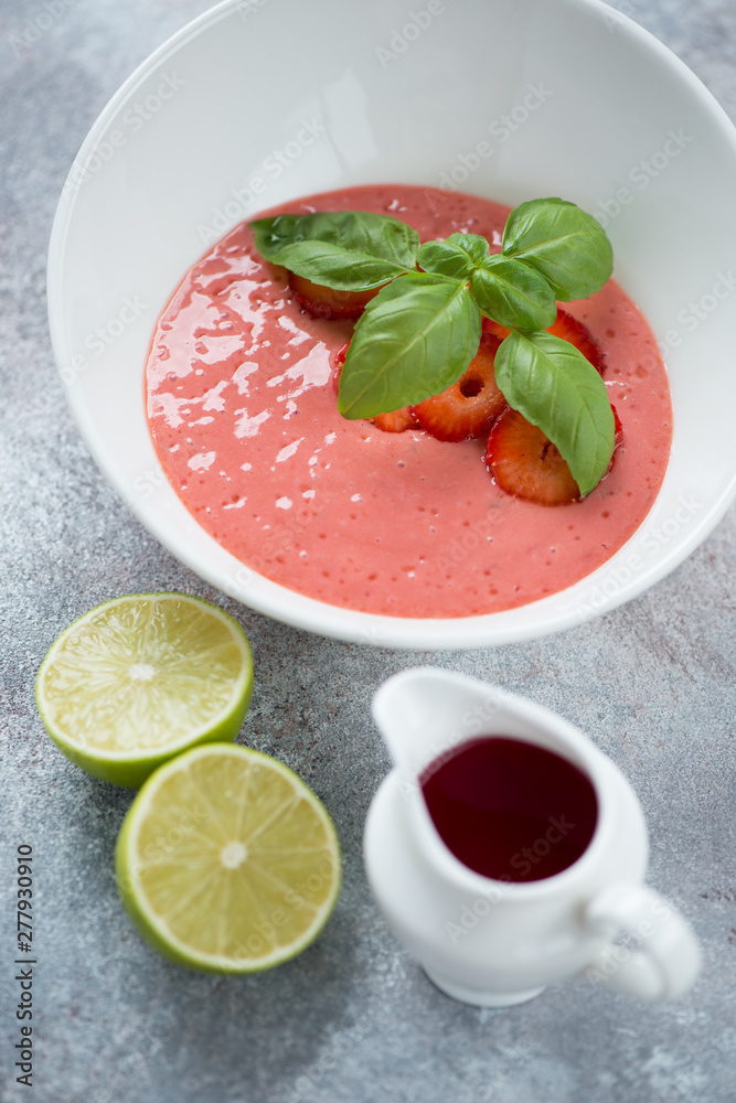 Closeup of cold summer soup made of fresh strawberries and served in a white bowl, vertical shot, elevated view Closeup of cold summer soup made of fresh strawberries and served in a white bowl, vertical shot, elevated view
