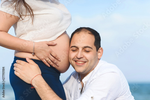 man listening belly of pregnant woman