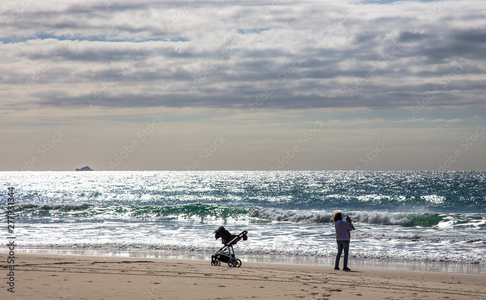Mulher na praia com seu filho