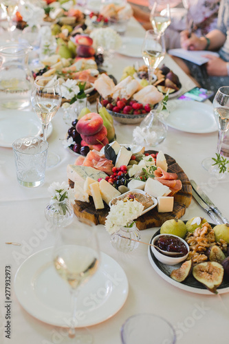 Beautifully decorated catering banquet table with different food snacks and appetizers with sandwich, caviar, fresh fruits on corporate party event or wedding celebration