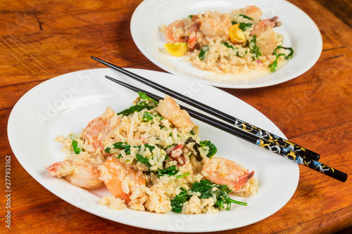 Serving Two Plates of Shrimp Stir Fry with Chopsticks on Rustic Wooden Table