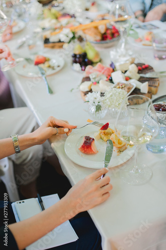 Wedding table setting. Festive table with white tablecloth. guests sit at the table. on the table are fruits, cheeses, glasses. cheese and wine tasting