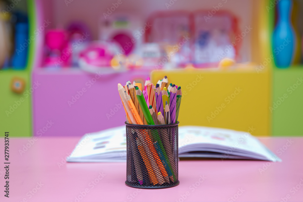 Colored pencils in a pencil case on blured background . Pen, pencil and accessory in black basket isolated on blured background . Colored pencils in a pencil case on blured background . Pen, pencil and accessory in black basket isolated on blured background .