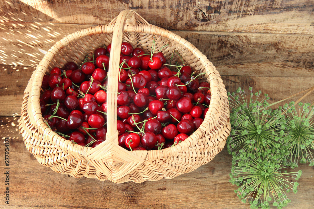 fresh cherries in a basket on wooden background fresh cherries in a basket on wooden background