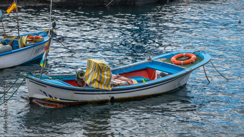 Closeup White Wooden Fishing Boat Moored in Glittering Water on the Beach, North Atlantic Ocean