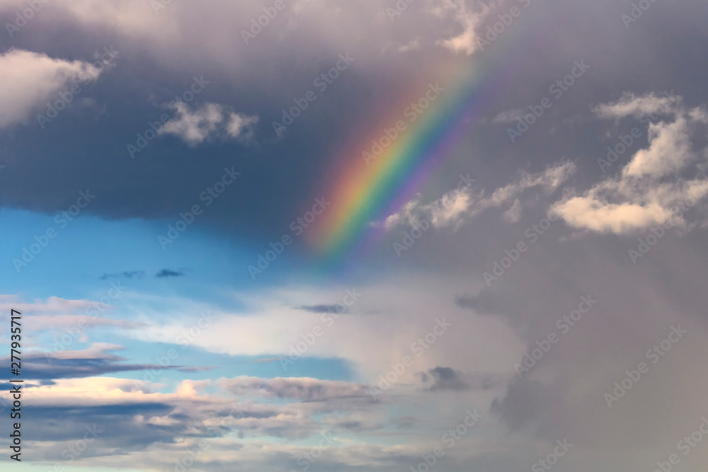 Colorful rainbow in the sky with clouds.