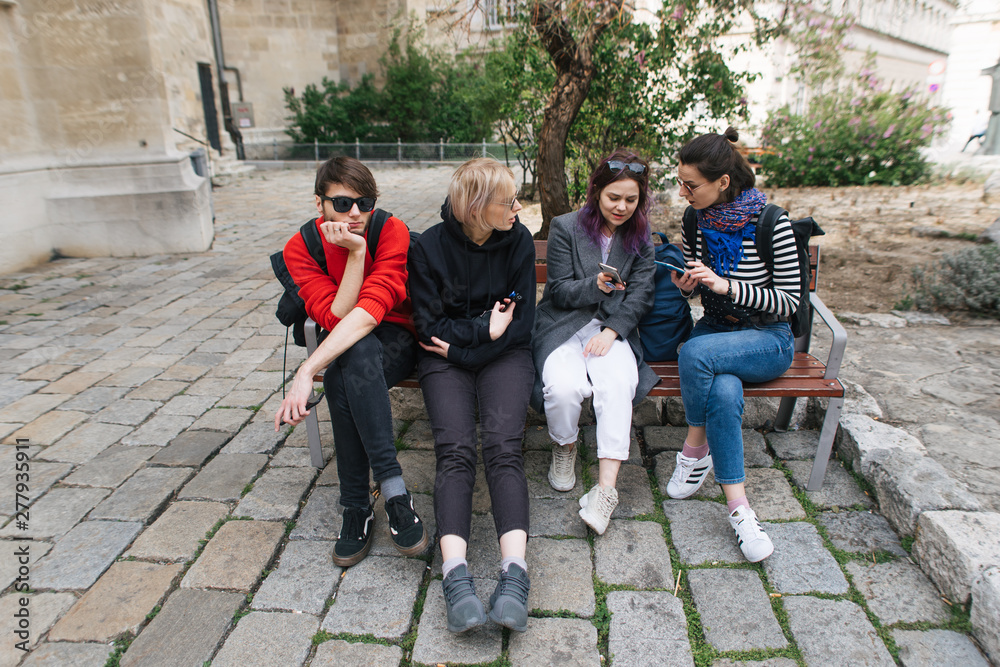 Fototapeta premium friends are sitting on bench and discuss something