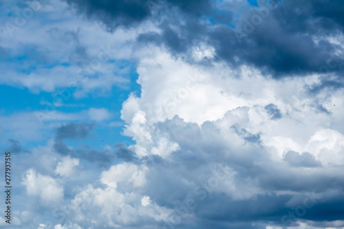 Cumulonimbus  clouds on a summer blue sky. Time before a thunderstorm. Abstract background