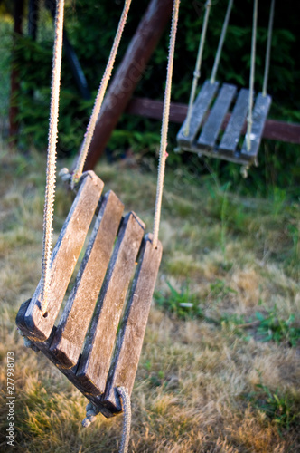 Old wooden broken children swing photo