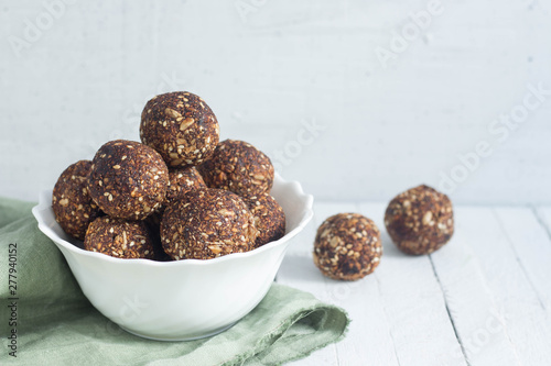appetizing energy balls in a  white bowl white wooden background