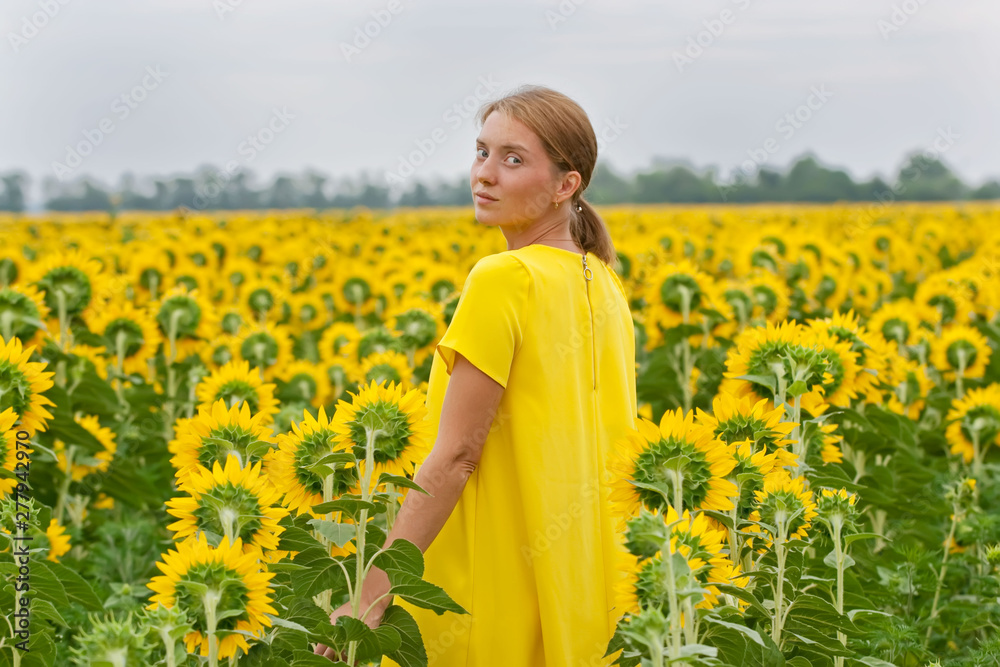 Woman in yellow dress in sunflower field Woman in yellow dress in sunflower field