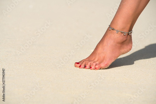 Close-up of female foot in the sand on the tropical beach. Vacation holidays.