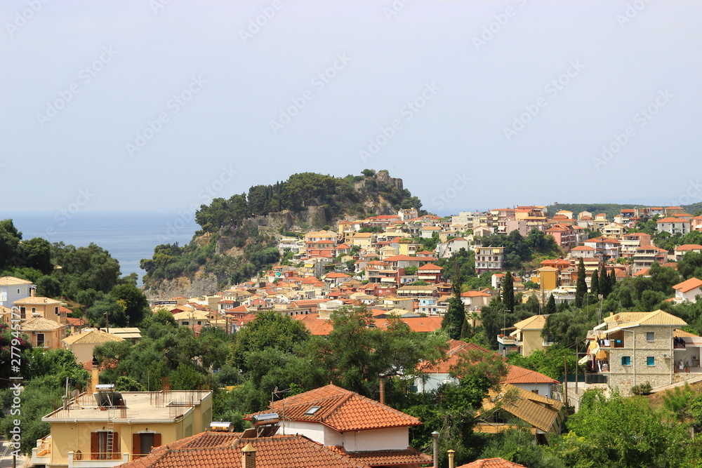Panoramic view from a hill of the traditional Greek village of Parga and the venetian castle. Background view of blue sea and sky