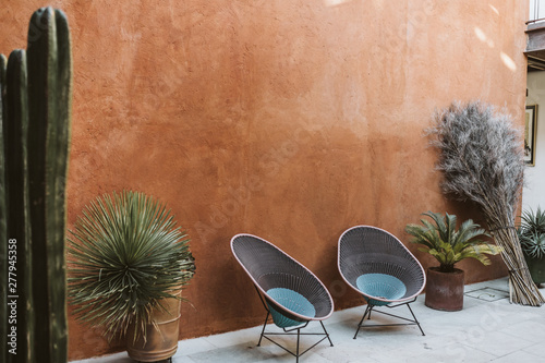 outdoor patio space with two empty chairs and potted cacti photo