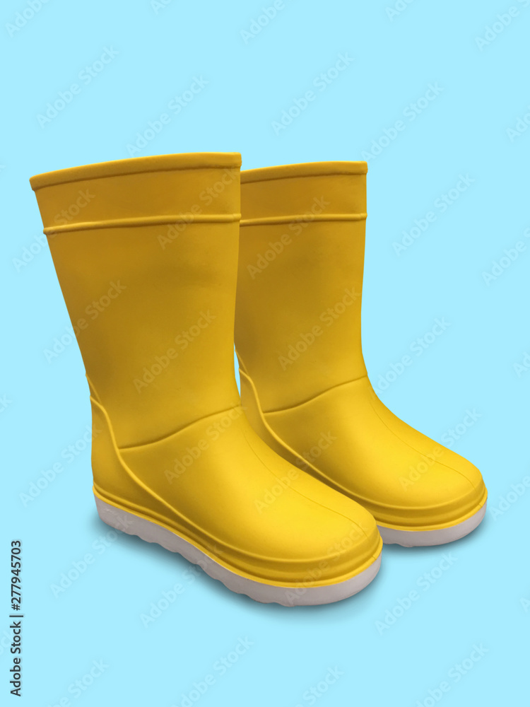 Yellow rubber boots on blue background. White sole Yellow rubber boots on blue background. White sole