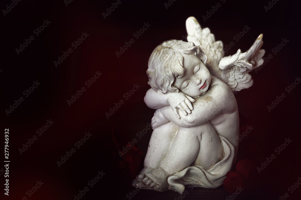 Guardian angel sleeping on black background with copy space