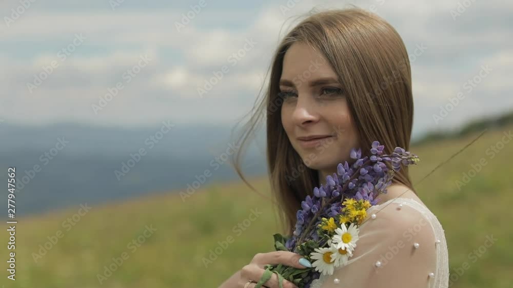 Close up shot of brides face. Bride in wedding dress stay with bouquet