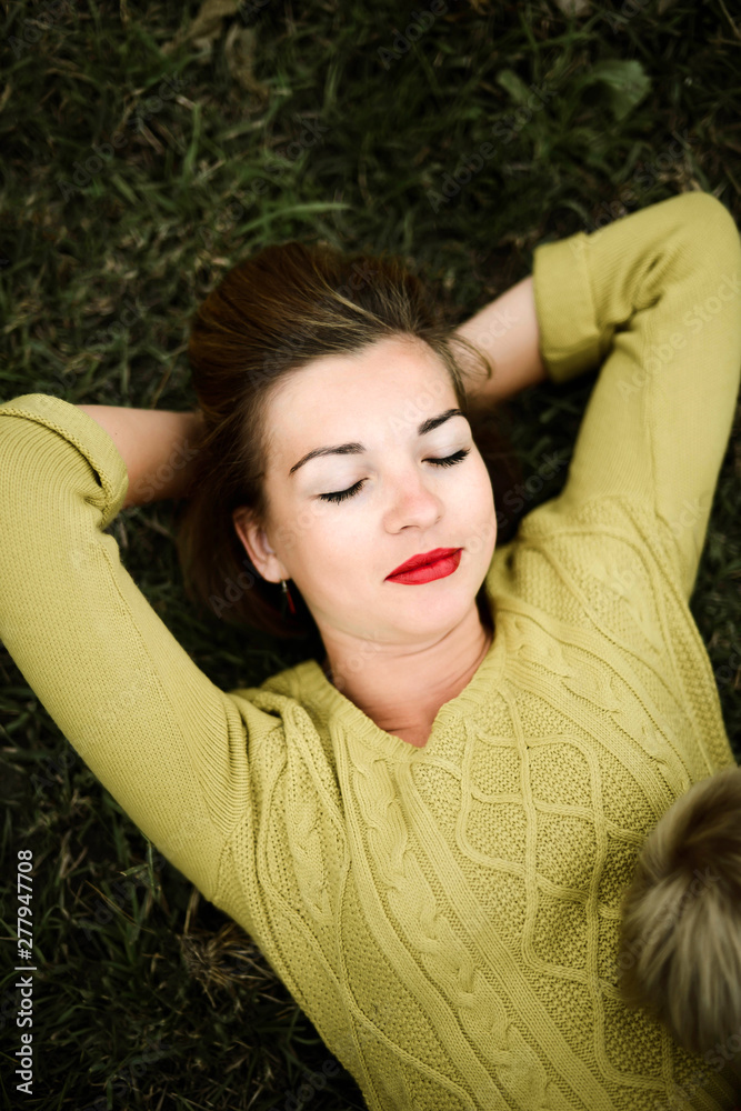 Young beautiful woman lying on grassy field Young beautiful woman lying on grassy field