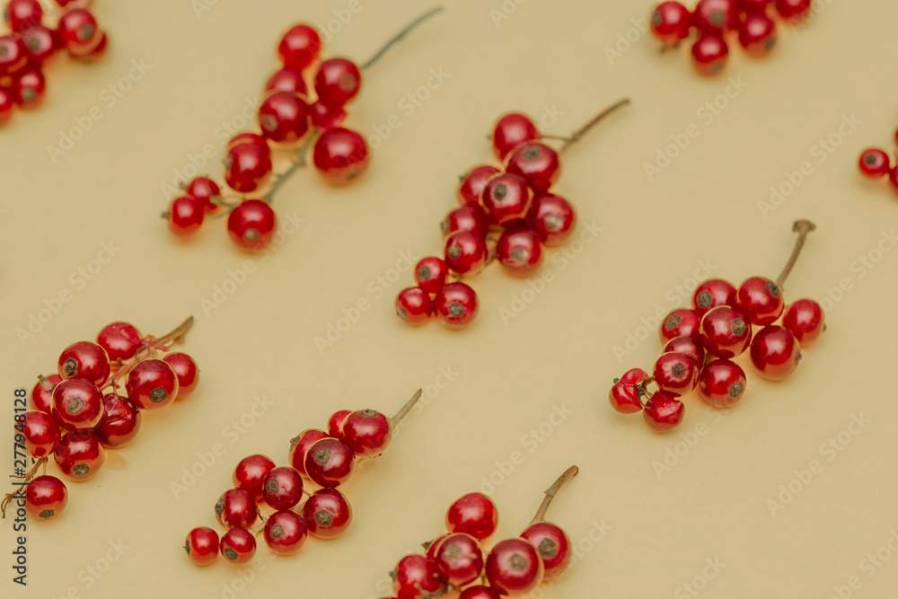 The pattern of juicy sweet fresh red currant berries on a yellow background. The pattern of juicy sweet fresh red currant berries on a yellow background.