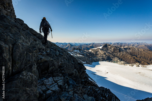 Climber traversing a rocky slope whilst mountaineering in New Zealand photo