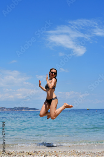 blonde woman jumping on the beach