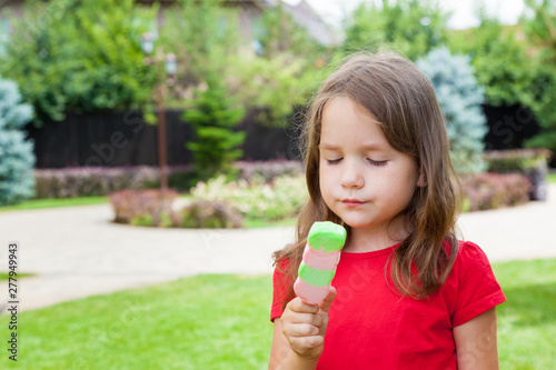 Cute Toddler Girl Eating Ice-Cream outdoors. Child on a walk in the park in summer day. Lifestyle  happy summertime  family vacations  summer outdoor portrait