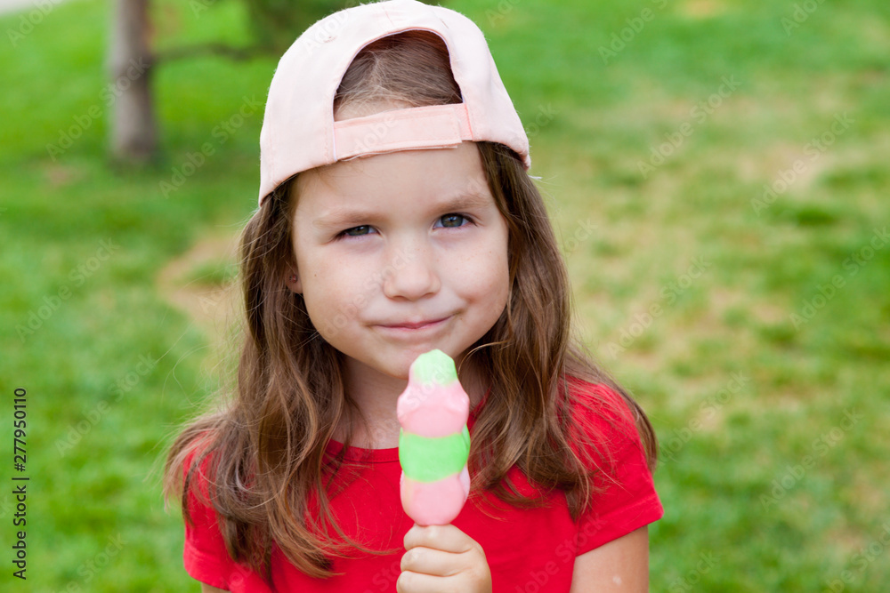 Cute Toddler Girl Eating Ice-Cream outdoors. Child on a walk in the park in summer day. Lifestyle, happy summertime, family vacations, summer outdoor portrait Cute Toddler Girl Eating Ice-Cream outdoors. Child on a walk in the park in summer day. Lifestyle, happy summertime, family vacations, summer outdoor portrait