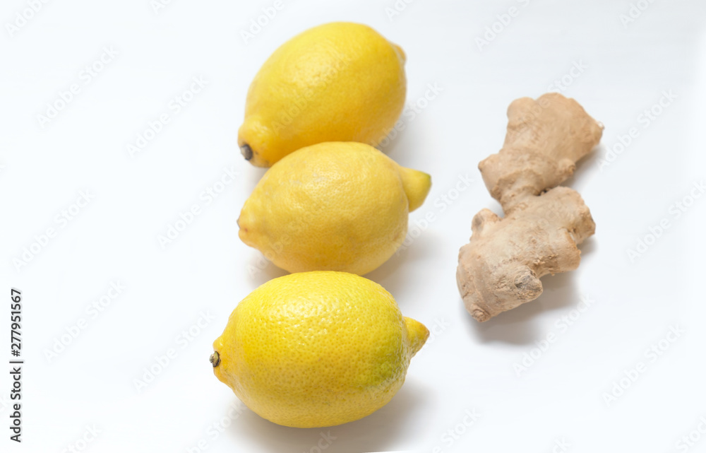 Three yellow lemons and ginger root on a light background. Three yellow lemons and ginger root on a light background.