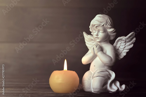 Angel and candle on dark background