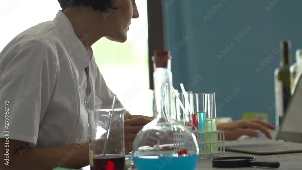 Scientist woman working on laptop in laboratory, slow motion Scientist woman working on laptop in laboratory, slow motion