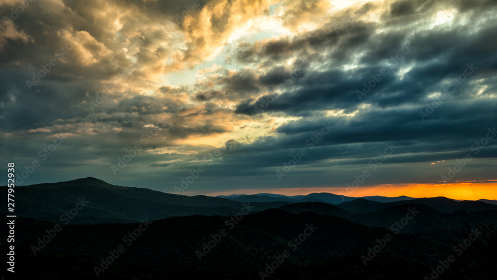 A wonderful sunset in the mountains. Orange sky and dark silhouettes of mountains. Carpathian Mountains landscape. Bieszczady. Poland A wonderful sunset in the mountains. Orange sky and dark silhouettes of mountains. Carpathian Mountains landscape. Bieszczady. Poland