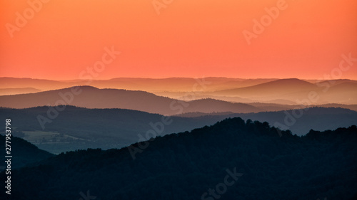 Fototapeta Naklejka Na Ścianę i Meble -  A wonderful sunset in the mountains. Orange sky and dark silhouettes of mountains. Carpathian Mountains landscape. Bieszczady. Poland
