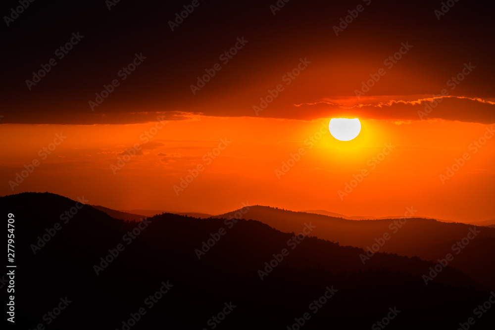 Fototapeta premium A wonderful sunset in the mountains. Orange sky and dark silhouettes of mountains. Carpathian Mountains landscape. Bieszczady. Poland