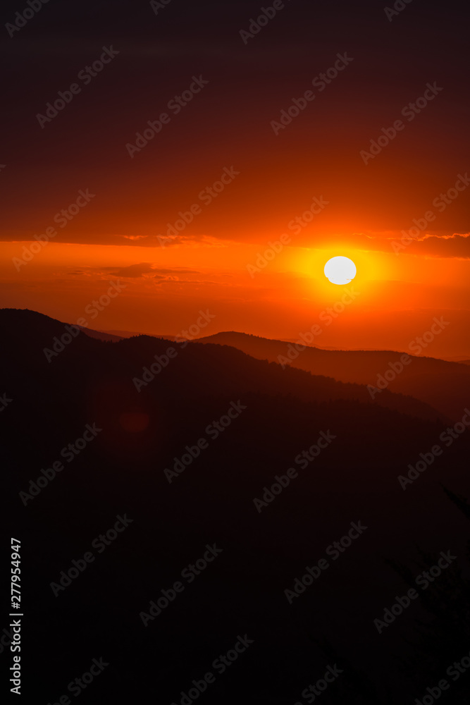 A wonderful sunset in the mountains. Orange sky and dark silhouettes of mountains. Carpathian Mountains landscape. Bieszczady. Poland