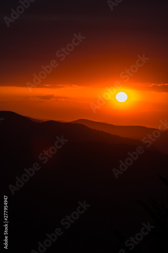 A wonderful sunset in the mountains. Orange sky and dark silhouettes of mountains. Carpathian Mountains landscape. Bieszczady. Poland